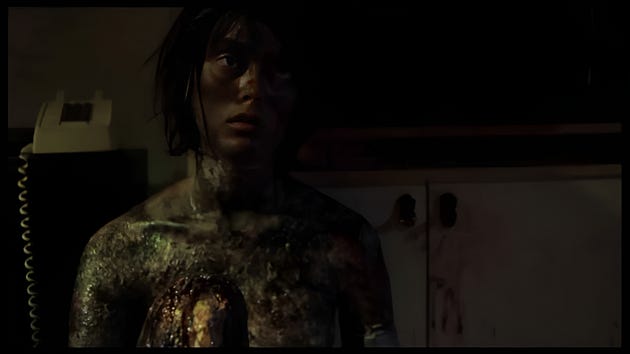 A distressed female character with an expressive face, showing signs of physical injury and distress, in a dimly lit room with a wall phone in the background.