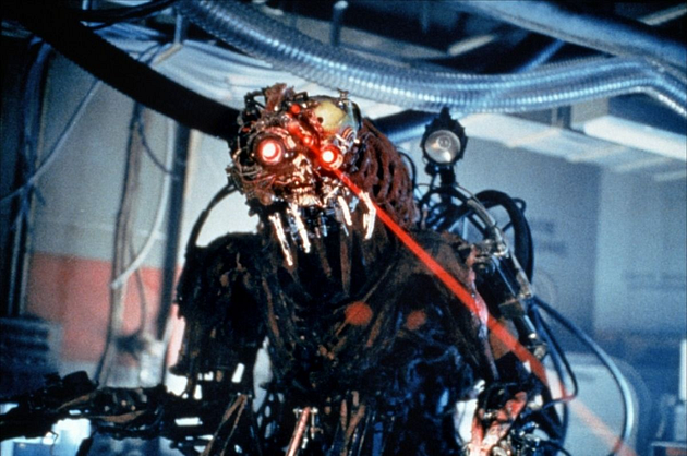 A robotic creature with glowing red eyes and metallic features, emitting a laser beam, set in an industrial environment.
